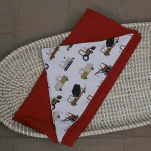 Opgevouwen omslagdoek met buitenzijde voertuigen print en binnenzijde wafeljersey kleur cognac.