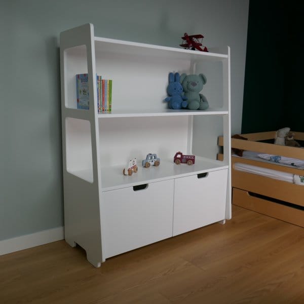 Een slaapkamer met een gevulde witte speelgoedkast.